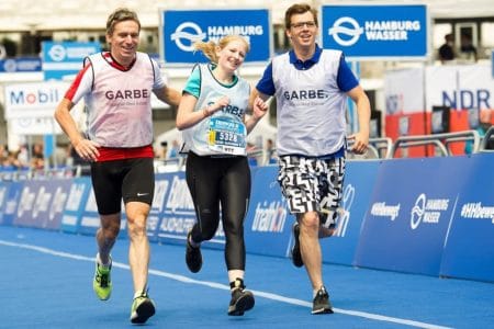 Eine Frau und zwei Männer laufen bei einem Marathon